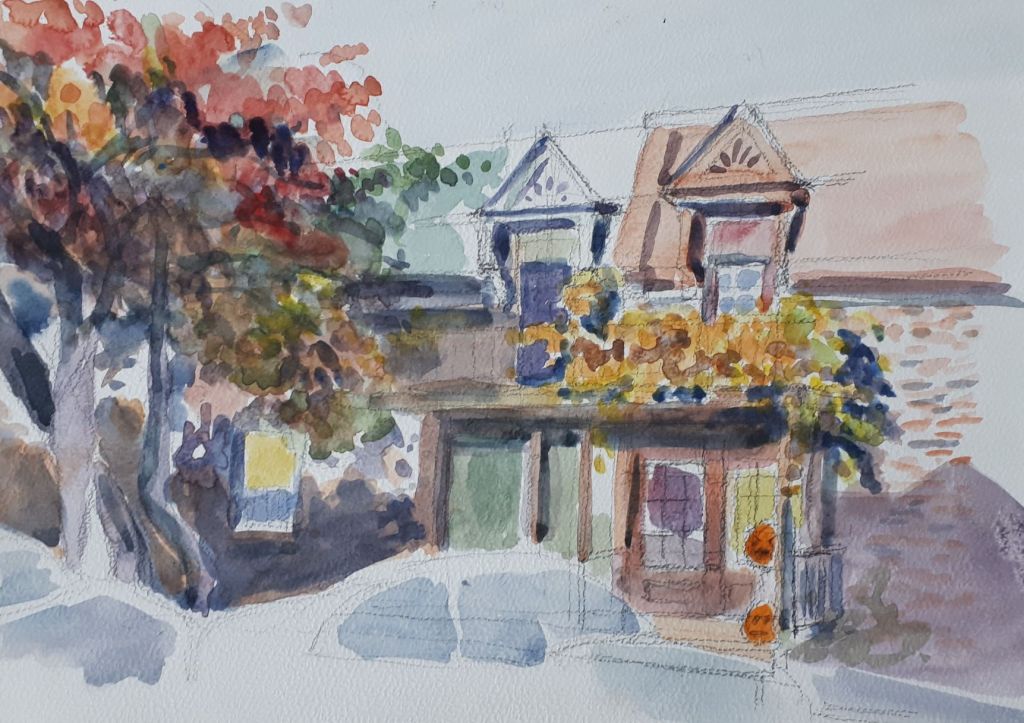 A watercolor painting depicting a charming house with colorful foliage and flowers, featuring a peaked roof and a front porch adorned with plants.