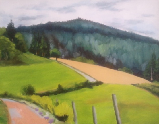 A scenic landscape featuring rolling green hills, a dirt road winding through the fields, and a distant mountain under a cloudy sky.